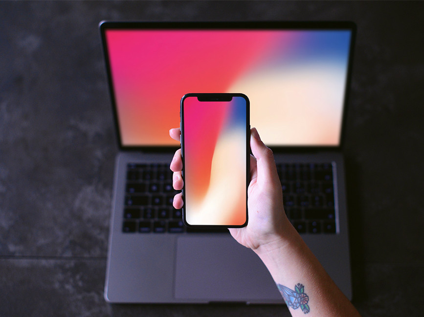 iPhone X in Hand with Macbook Mockup